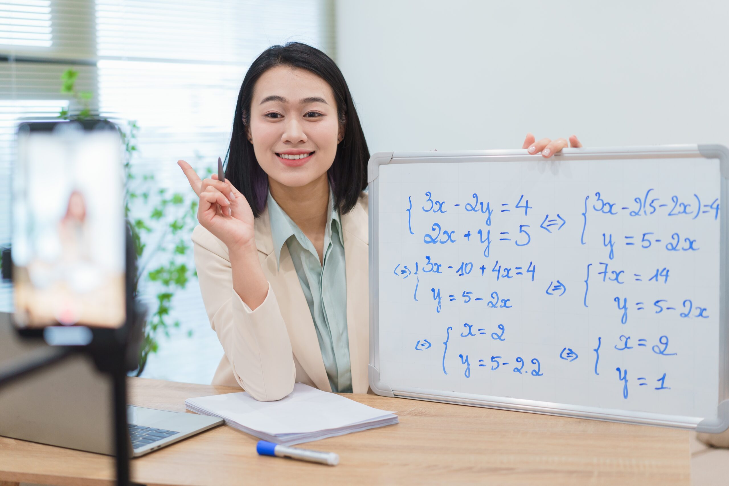 Math tutor explaining equations on whiteboard